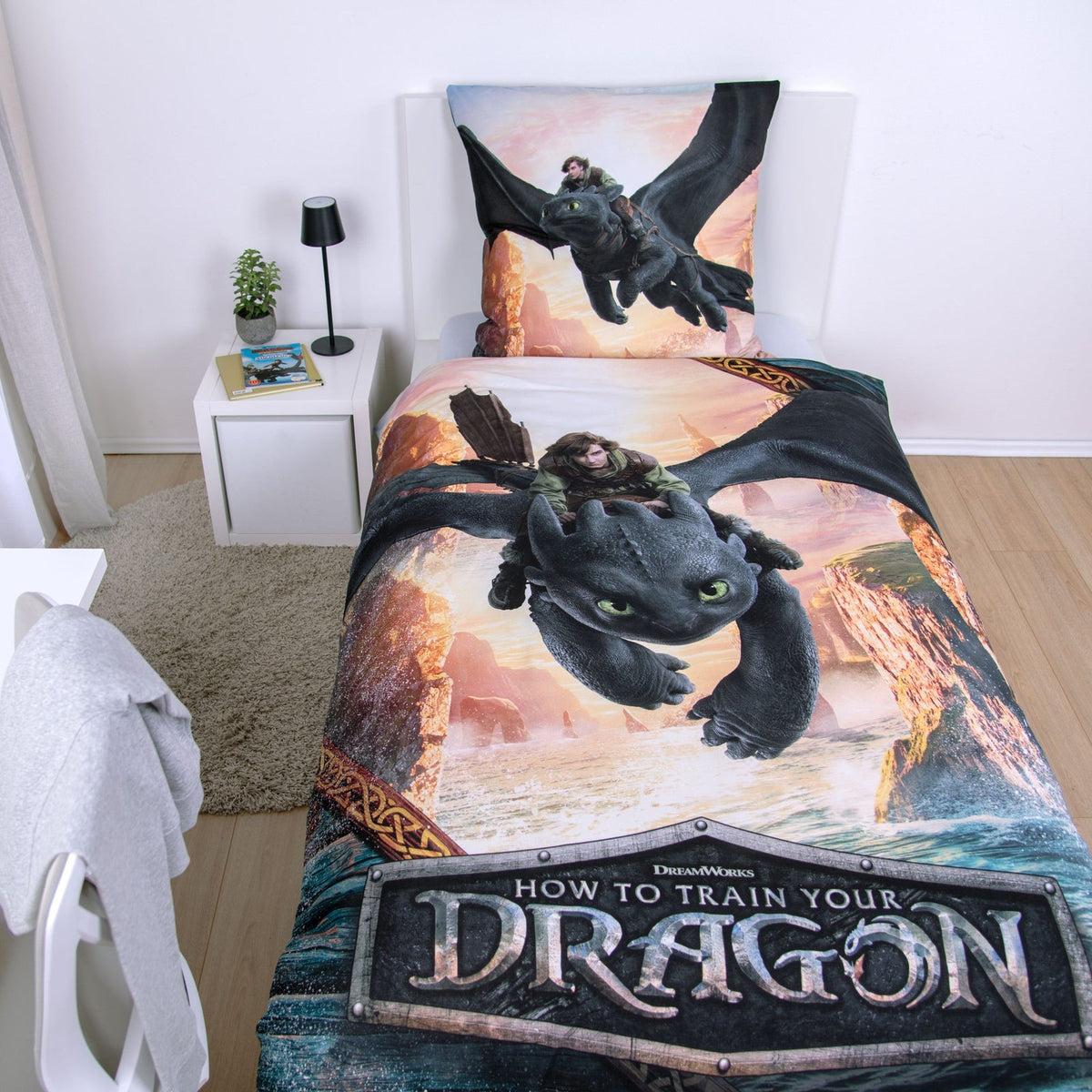 Dragons Bettwäsche ‘Drachenreiter’ von oben auf einem Einzelbett mit Logo