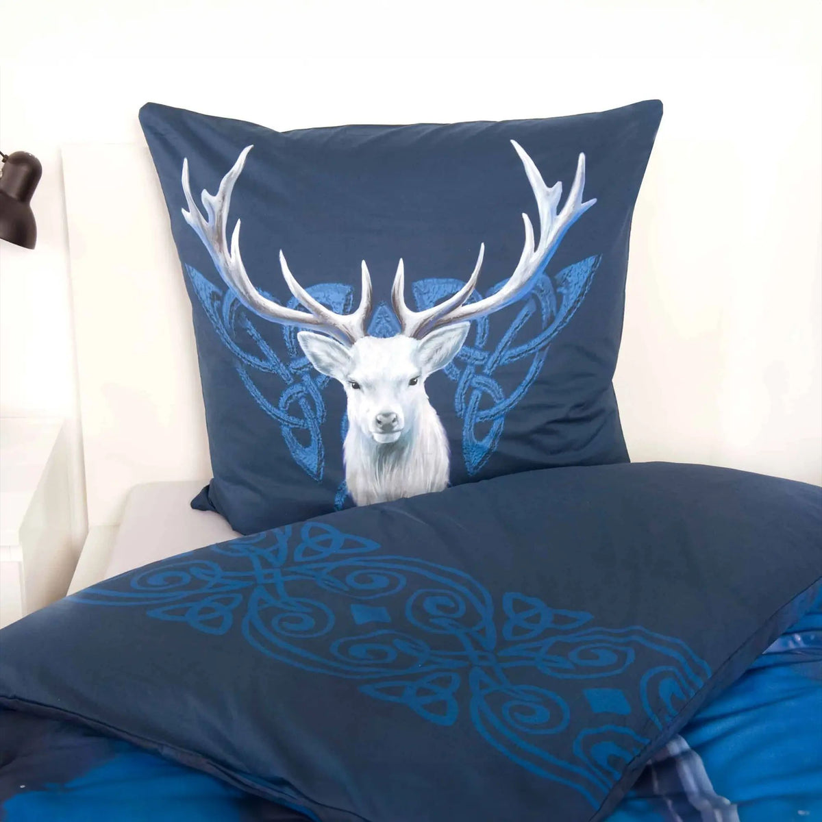 Kissen mit dem Kopf des weißen Hirschs und blauen Ornamenten