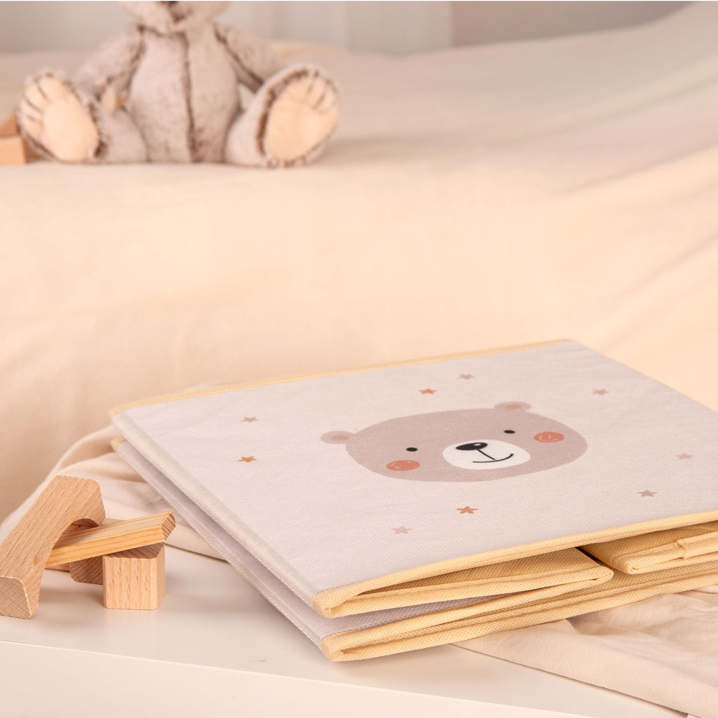 Flach zusammengefaltete Aufbewahrungsbox ‘Little Friends’ mit Bärenmotiv neben Holzbausteinen