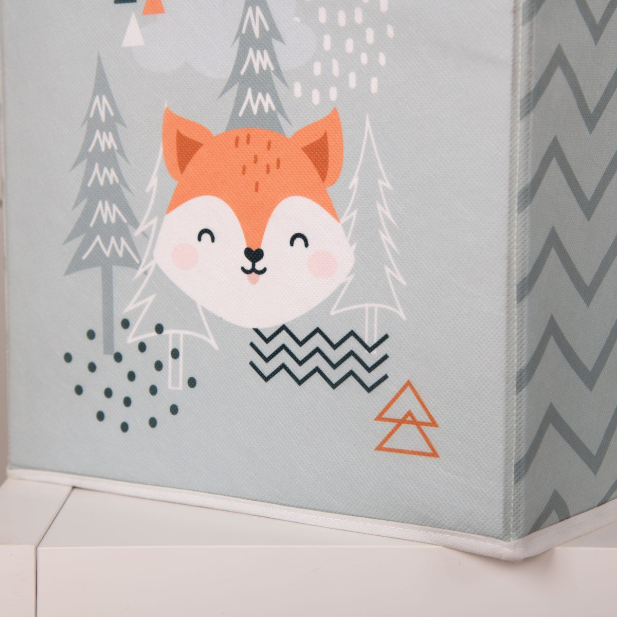 Aufbewahrungsbox ‘Nordic Forest’ mit Fuchs zwischen Tannen auf einem weißen Regal