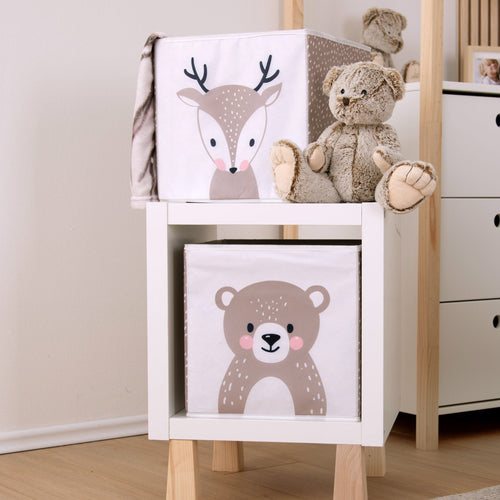 Aufbewahrungsbox ‘Woodland Crew’ mit Reh auf einem Regalwürfel neben einem Teddy, darin die Box mit dem Bären