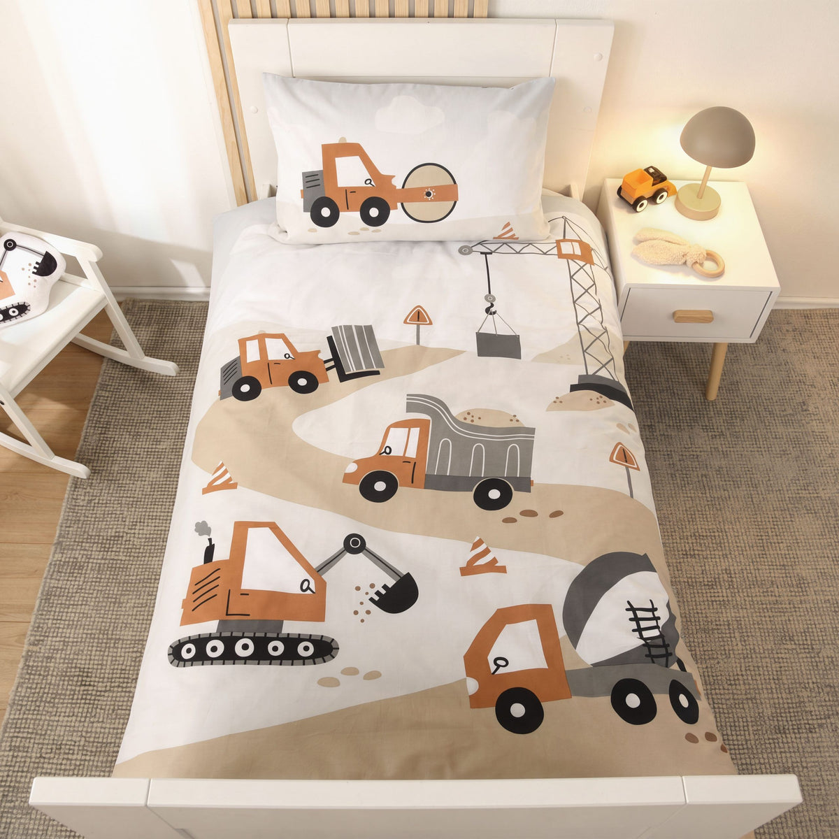 Bettwäsche ‘Baustelle’ auf einem weißen Kinderbett mit Nachttisch