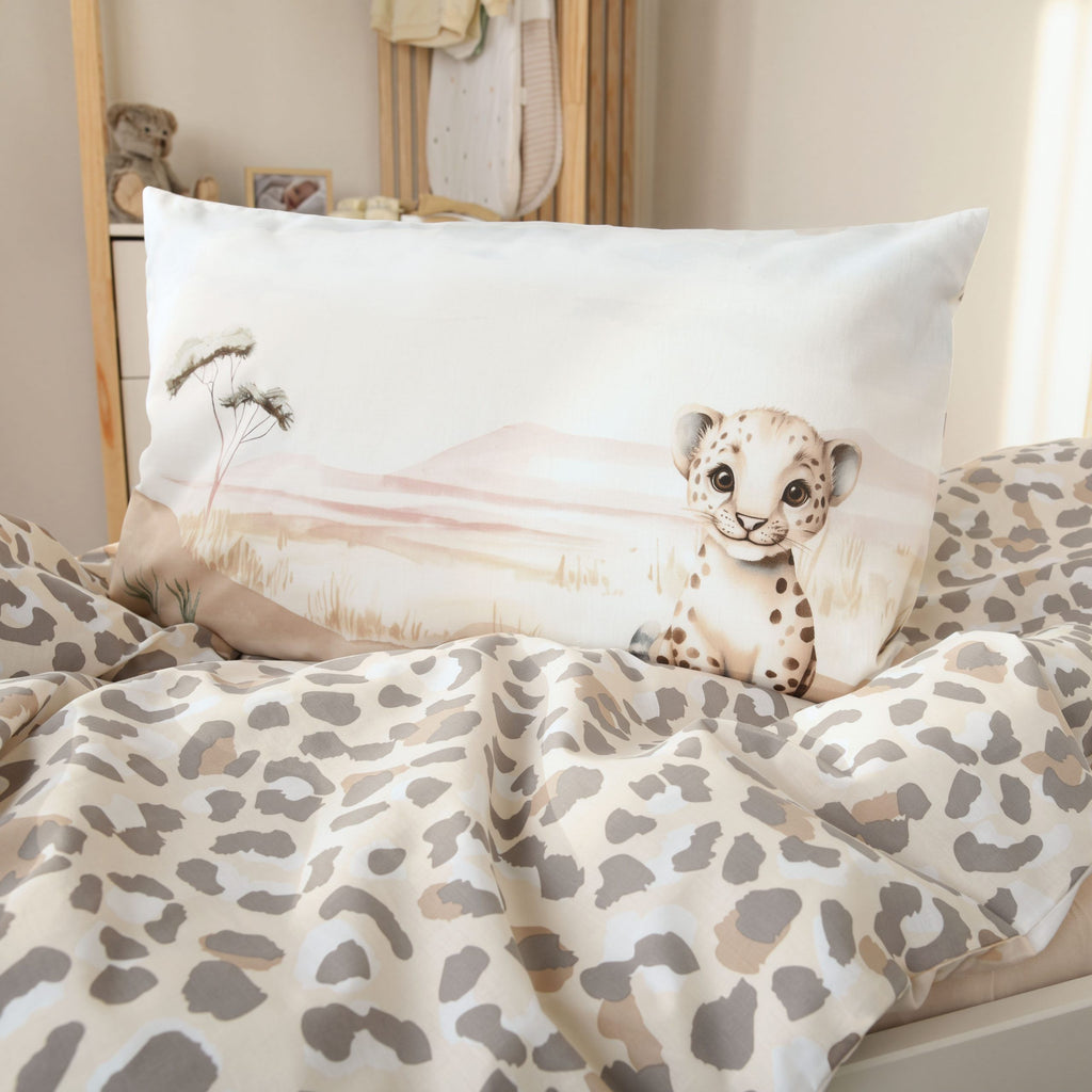 Kissen mit dem Leopardenbaby auf dem Bettbezug mit Leomuster