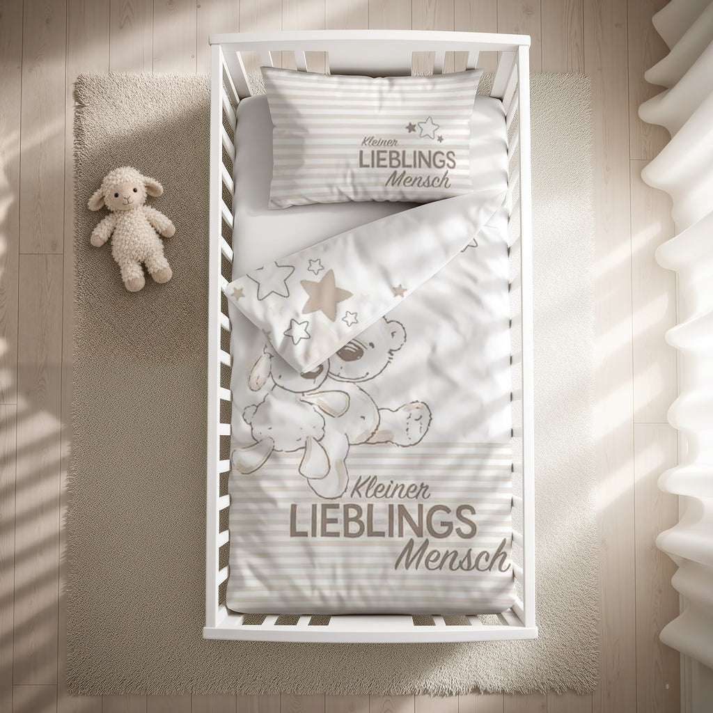 babybest Bettwäsche-Set ‘Kleiner Lieblingsmensch’ Beige 100 x 135 cm mit Kissenbezug 40 x 60 cm im Gitterbett, Draufsicht mit umgeschlagener Sternen-Wendeseite