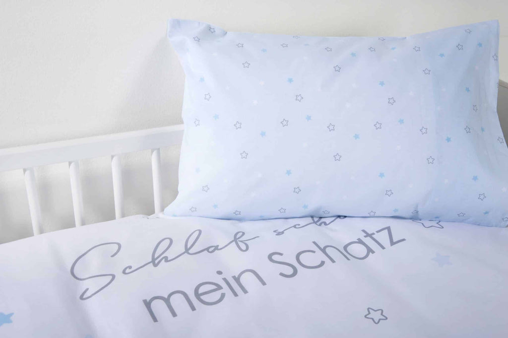 Hellblaues Kissen mit Sternen auf dem Bettbezug mit Schriftzug