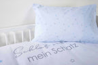 Hellblaues Kissen mit Sternen auf dem Bettbezug mit Schriftzug