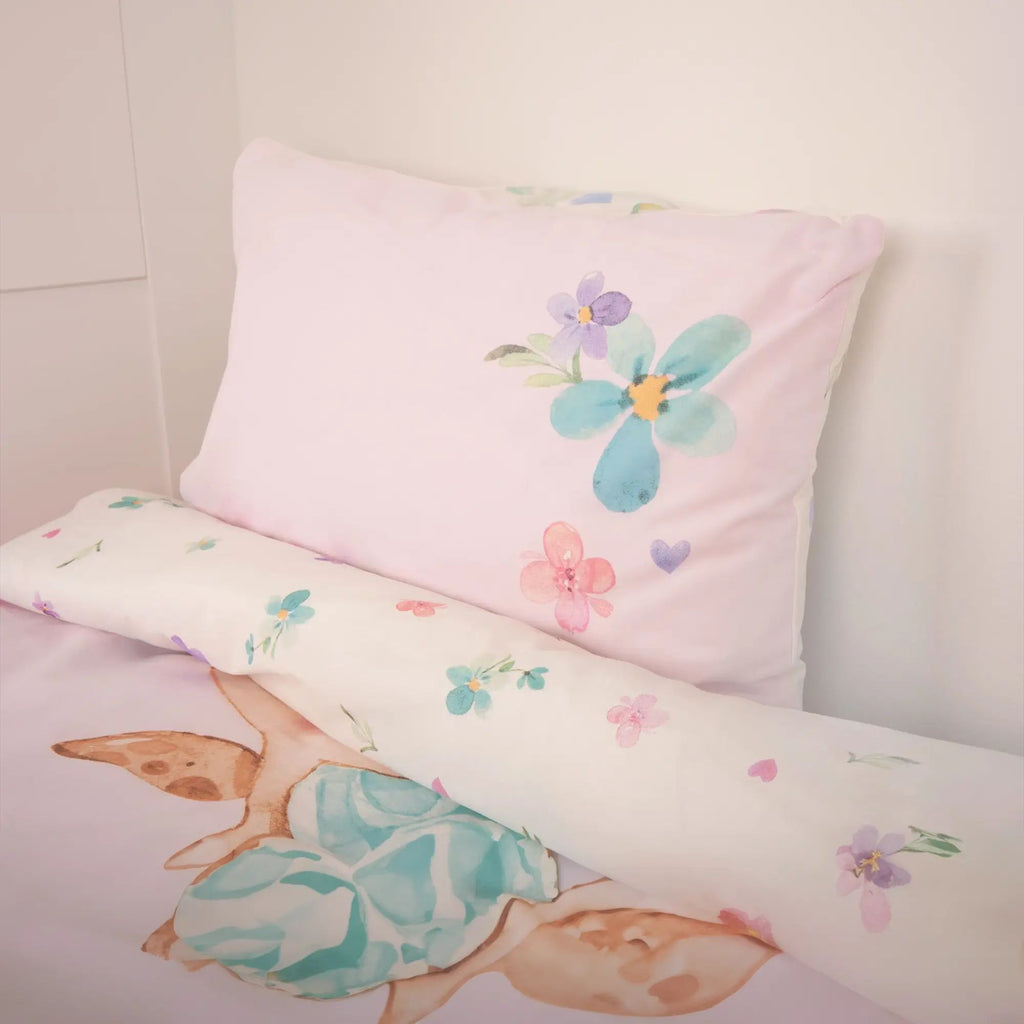 Kissen mit Blüten auf Rosa und umgeschlagene weiße Wendeseite mit Blüten
