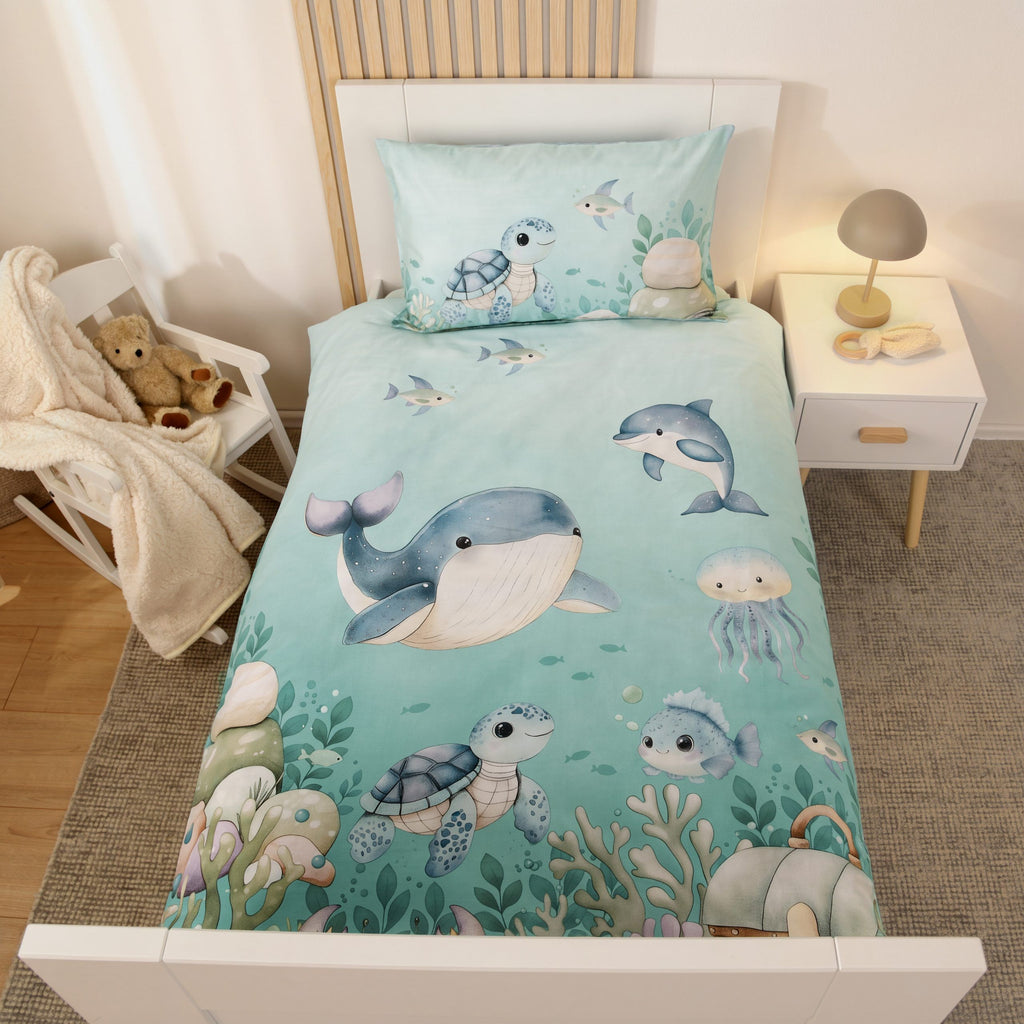 babybest Bettwäsche ‘Ozeanfreunde’ von oben auf einem weißen Kinderbett