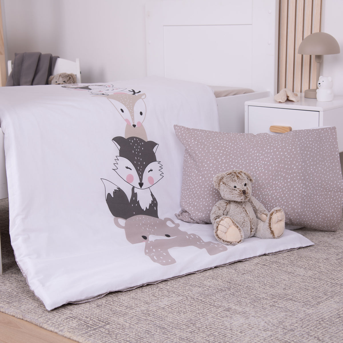 babybest Bettwäsche ‘Woodland Crew’ auf einem Kinderbett: Bettbezug mit Fuchs und Bär, Kissenbezug mit gepunkteter Rückseite