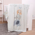 babybest Kuscheldecke ‘Elephants’ über dem Rand eines weißen Babybetts