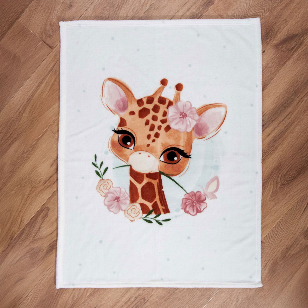babybest Kuscheldecke ‘Giraffe’ ausgebreitet auf einem Holzboden