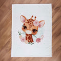 babybest Kuscheldecke ‘Giraffe’ ausgebreitet auf einem Holzboden
