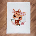 babybest Kuscheldecke ‘Giraffe’ ausgebreitet auf einem Holzboden