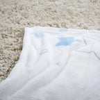 Kuscheldecke ‘Kleiner Lieblingsmensch’ in Blau auf einem hellen Hochflorteppich