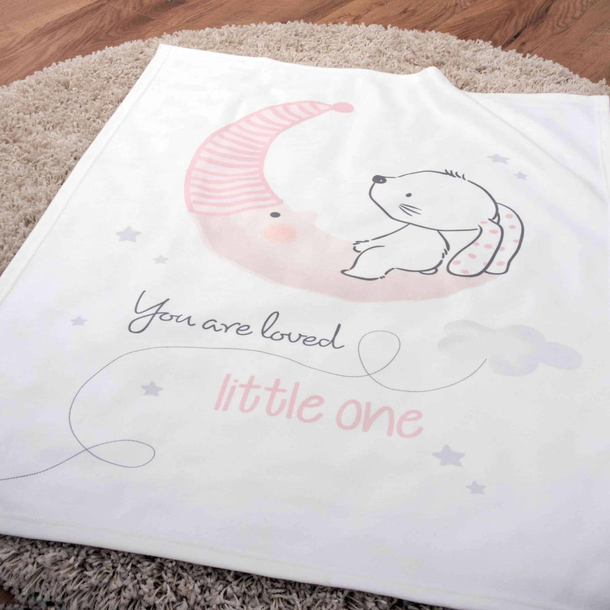 Kuscheldecke ‘Little Bunny’ auf einem runden Teppich