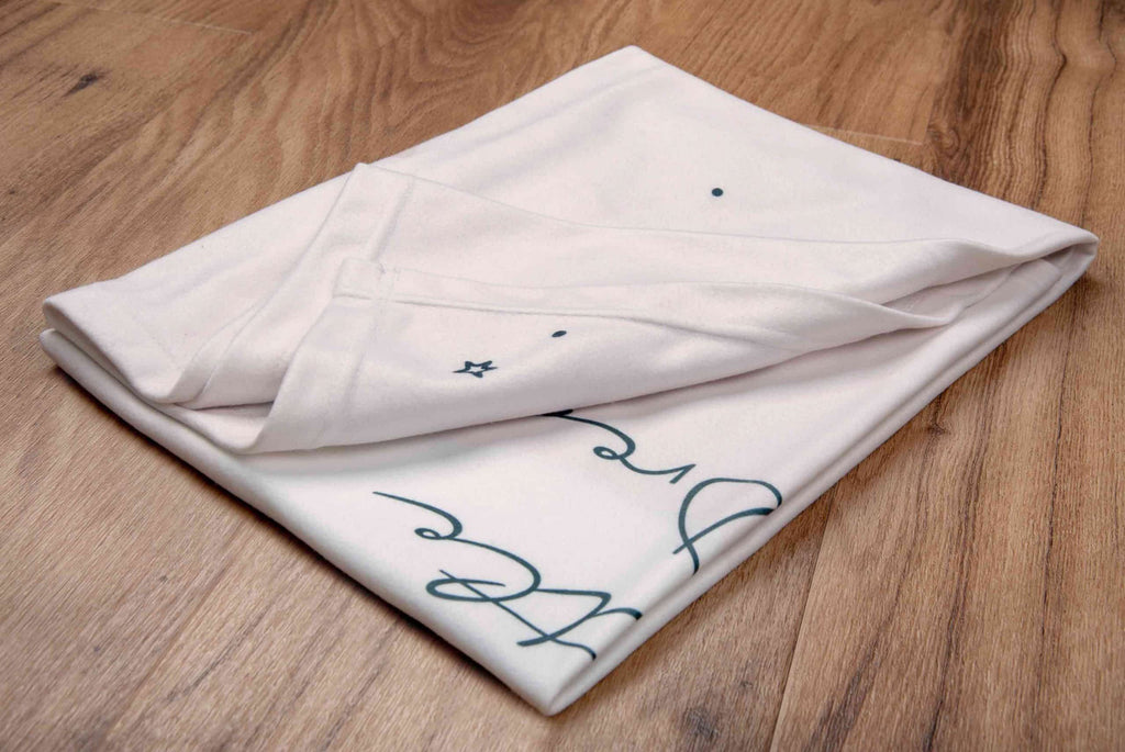Zusammengelegte Kuscheldecke ‘Little Dreamer’ mit einem Teil des Schriftzugs