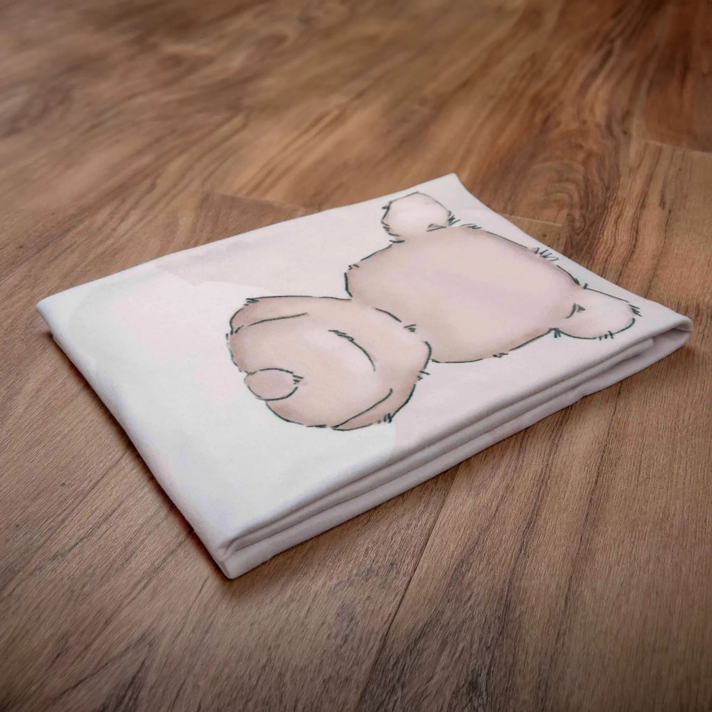 Zusammengelegte Kuscheldecke ‘Little Dreamer’ mit dem Teddy auf einem Holzboden