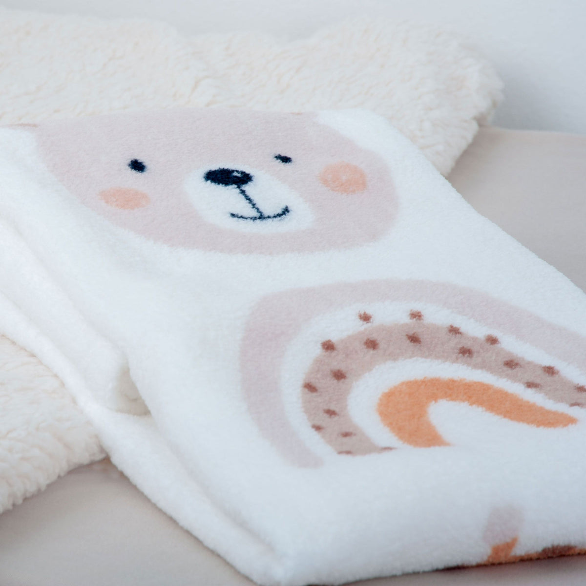 Nahaufnahme von Bär und Regenbogen auf der Kuscheldecke ‘Little Friends’
