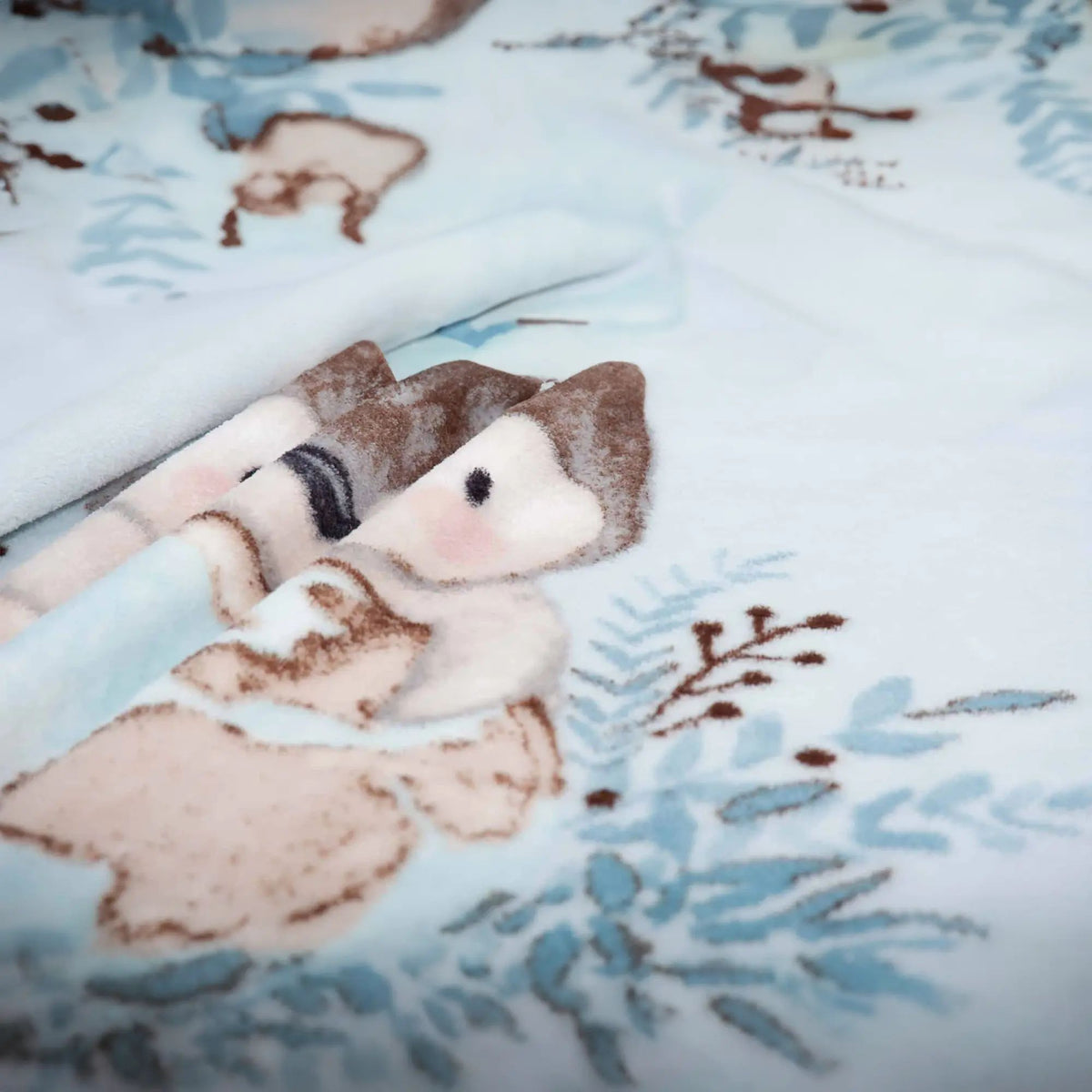 Nahaufnahme des Pinguins und der Zweige auf der Kuscheldecke