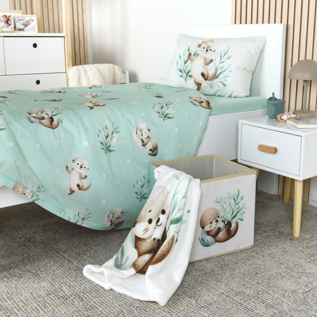Kinderzimmer mit Otter-Bettwäsche, die Kuscheldecke ‘Schnuffel-Otter’ hängt über einer Aufbewahrungsbox