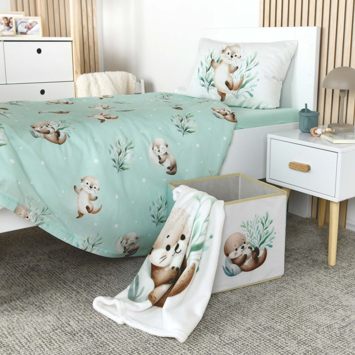Kinderzimmer mit Otter-Bettwäsche, die Kuscheldecke ‘Schnuffel-Otter’ hängt über einer Aufbewahrungsbox