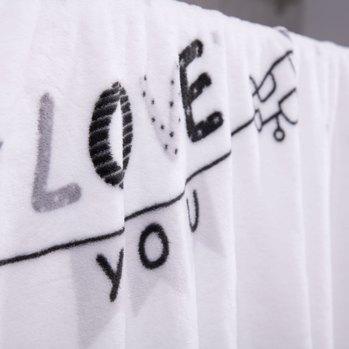 Nahaufnahme der Wimpelkette „LOVE YOU“ auf der Flauschdecke ‘Sleeping little Bear’
