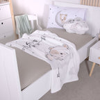 Flauschdecke ‘Sleeping little Bear’ auf einem Bett mit hellgrauem Laken
