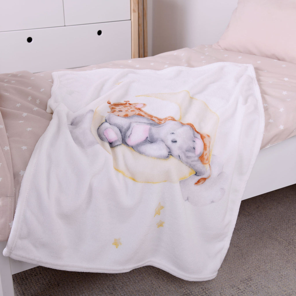 babybest Kuscheldecke ‘Sleeping on the Moon’ auf einem Kinderbett mit beiger Bettwäsche