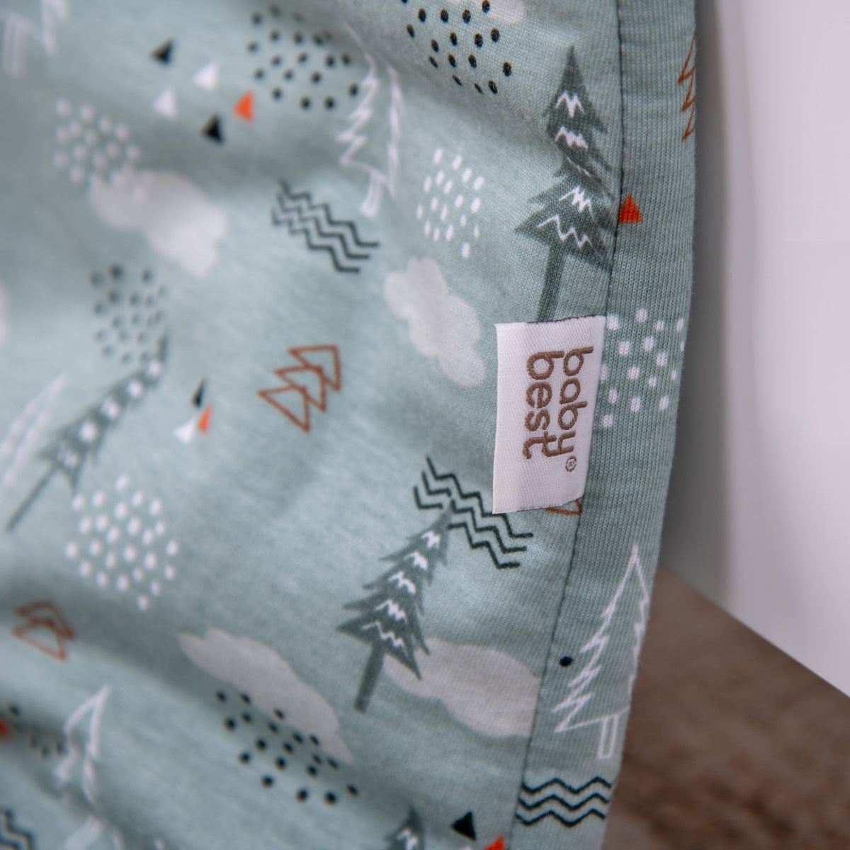 babybest-Label und Tannenmuster auf dem Schlafoverall