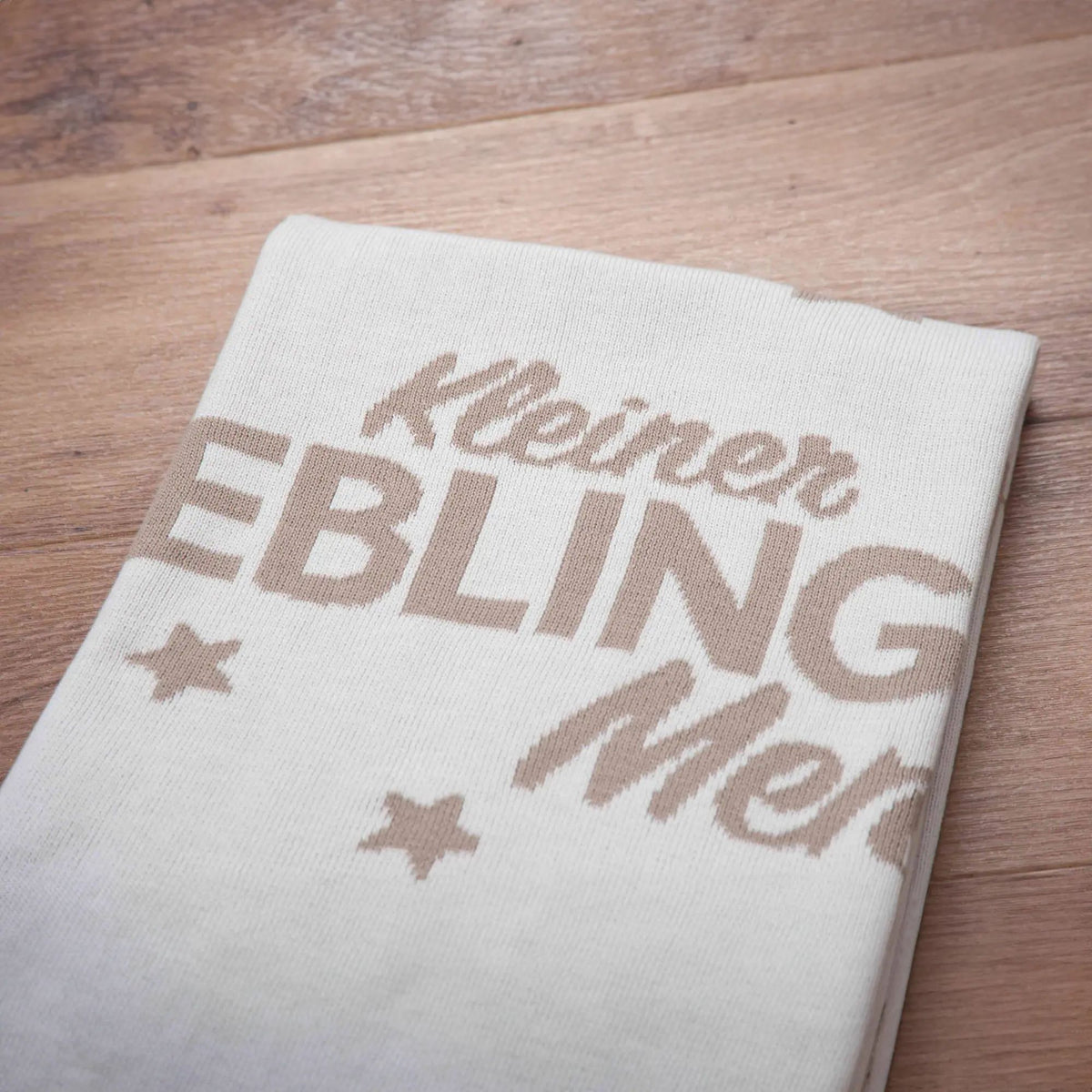 Nahaufnahme des eingestrickten Schriftzugs „Kleiner Lieblingsmensch“