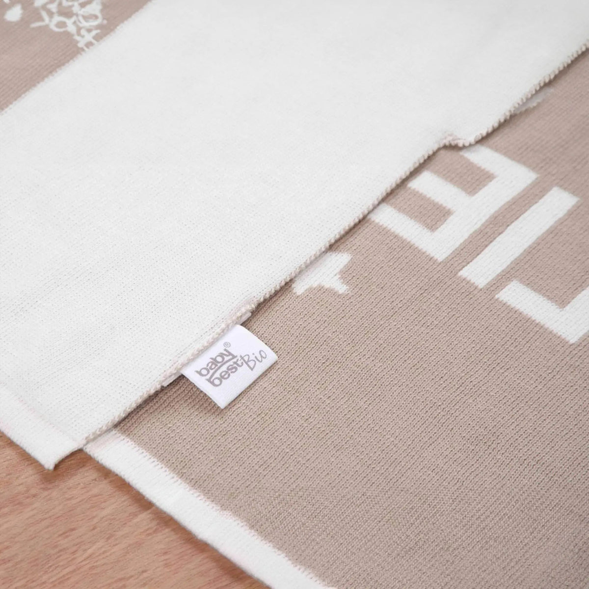 Vorder- und Rückseite der Strickdecke übereinander mit babybest-Etikett