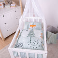 babybest Wiegenbettwäsche ‘Nordic Forest’ in einer weißen Wiege im Kinderzimmer