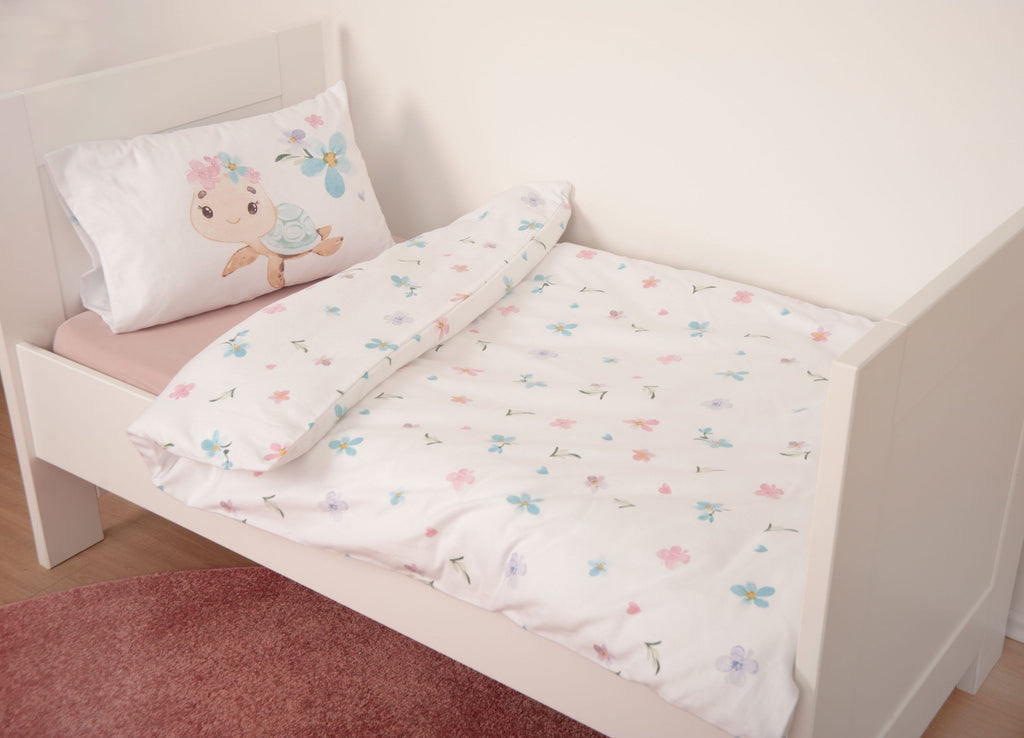 babybest Winterbettwäsche ‘Blütenschildkröte’ auf einem weißen Kinderbett