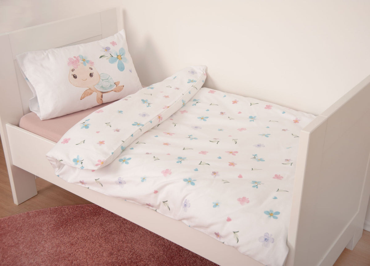 babybest Winterbettwäsche ‘Blütenschildkröte’ auf einem weißen Kinderbett