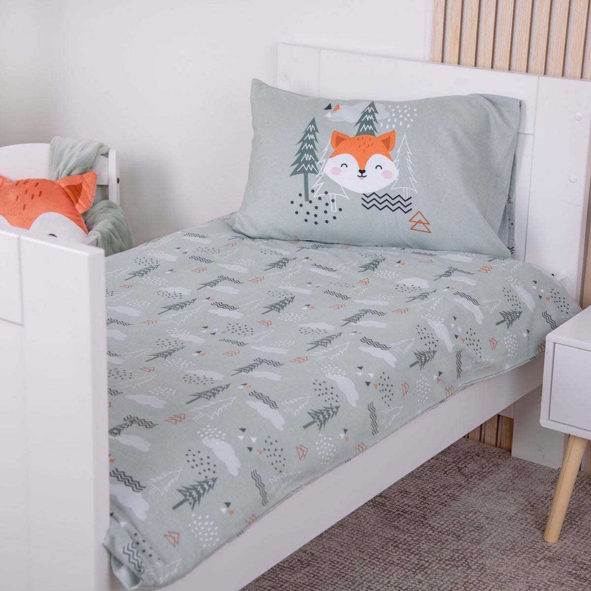 babybest Winterbettwäsche ‘Tannenwald’ auf einem Kinderbett, Kissen mit Fuchs