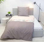 Bench Bettwäsche ‘Blumen’ frontal auf einem Bett mit grauem Kissen
