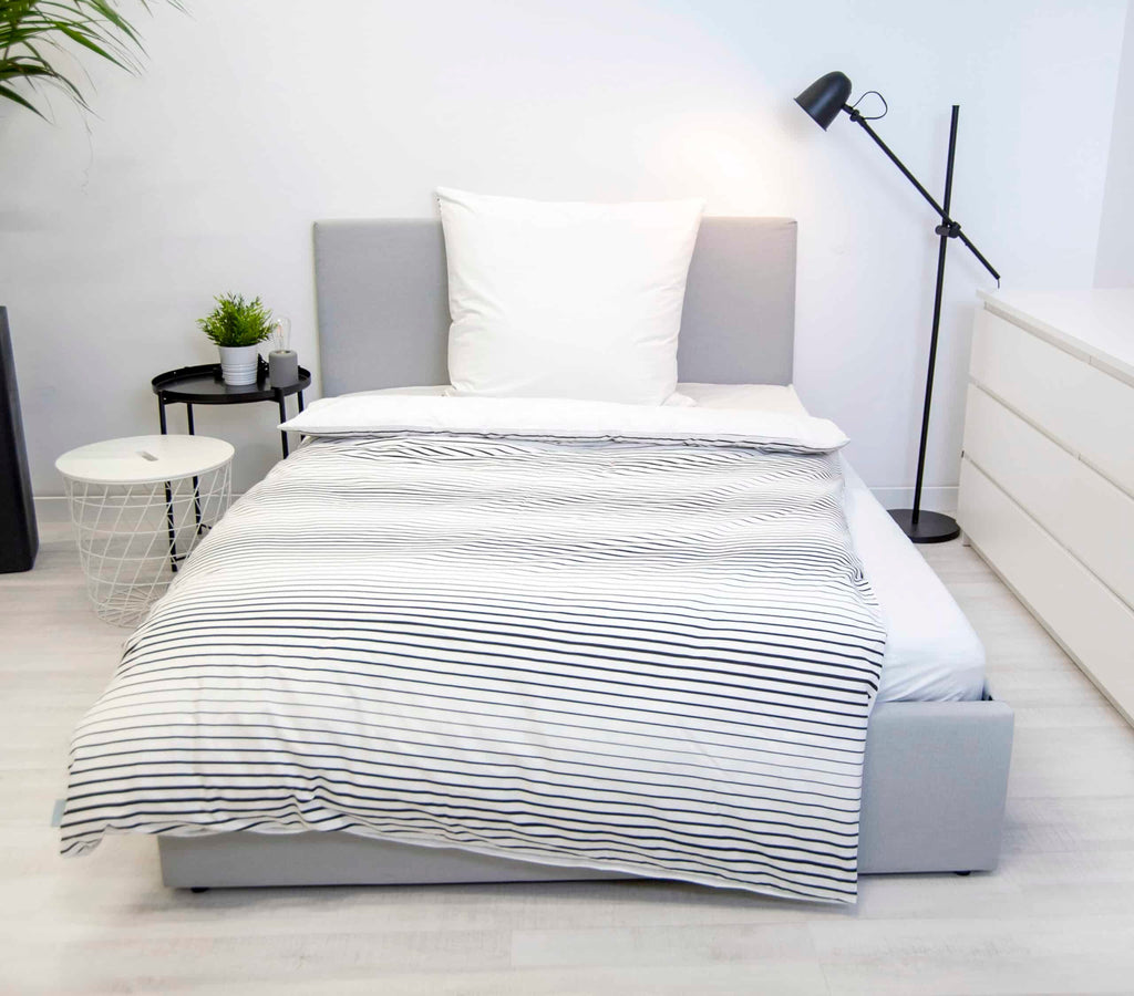 Bench Bettwäsche ‘Gestreift’ mit schwarz-weiß gestreifter Rückseite auf einem Bett