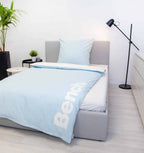 Bench Bettwäsche ‘Hellblau’ auf einem Bett, Logo am Bettbezug