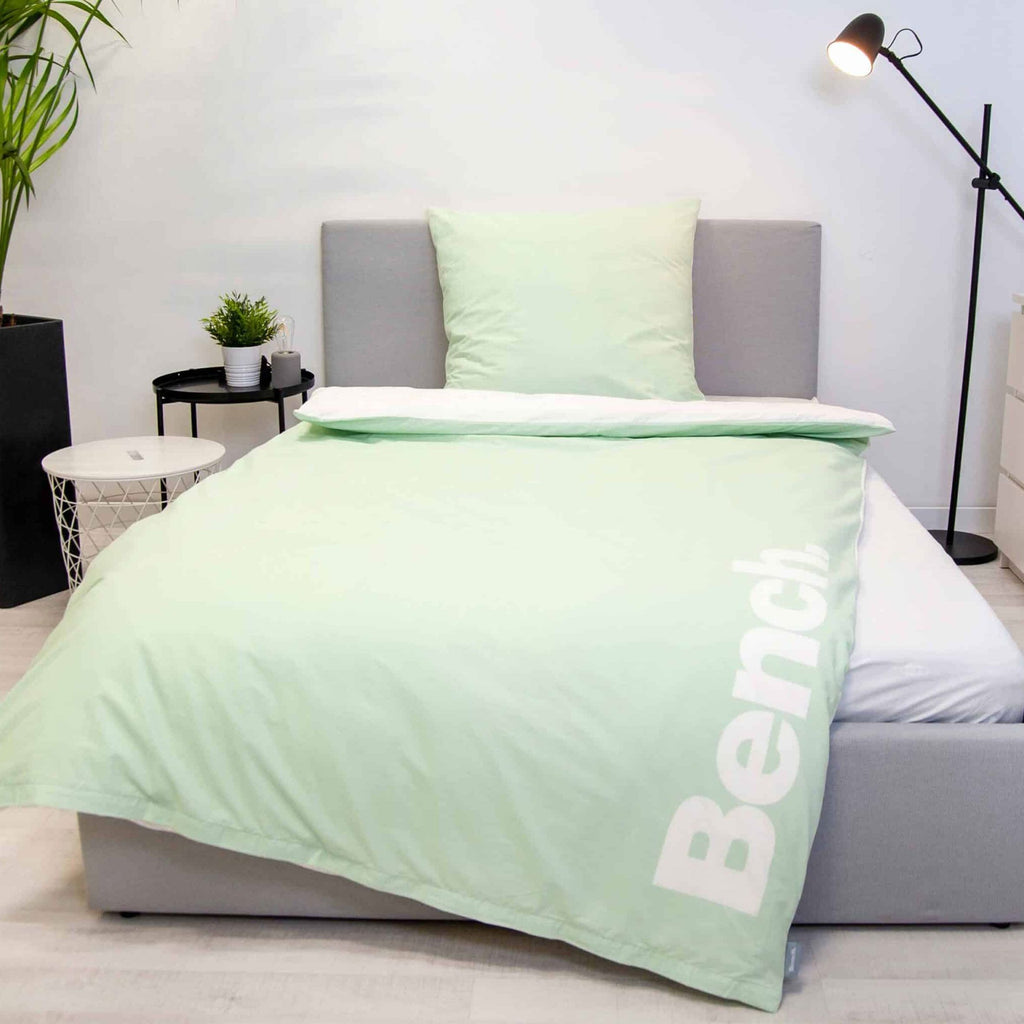 Bench Bettwäsche ‘Hellgrün’ auf einem grauen Polsterbett, hellgrüne Logo-Seite