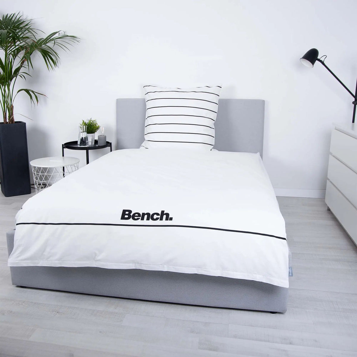 Bench Bettwäsche ‘Weiß/Gestreift’ frontal auf einem Bett mit gestreiftem Kissen