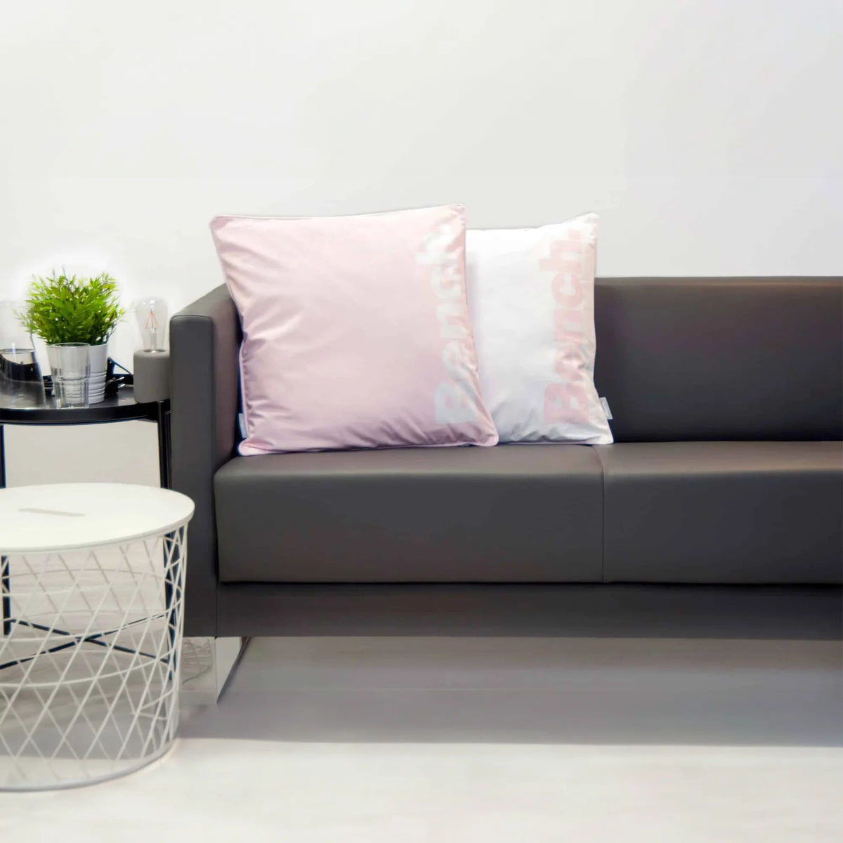 Bench Kissenhüllen in Hellrosa auf einem grauen Sofa