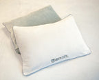 Zwei Bench Kissenhüllen Grau: hellgraue Seite mit gesticktem Bench-Schriftzug vor einer Hülle mit grauer Seite
