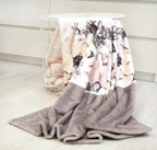 Bench Kuscheldecke im Design Blumen über einem weißen Drahtkorb