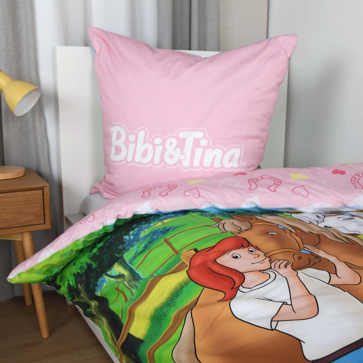 Kissen mit Bibi-&-Tina-Schriftzug auf Rosa und aufgeschlagener Bettbezug