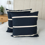 Zwei Kissen mit der Hülle ‘Sea Stripes’ auf einem Bett