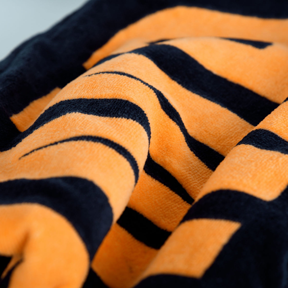 Orangefarbene Buchstaben auf dem Saunatuch ‘Logo Navy’ in Nahaufnahme