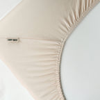 Ecke des CAMP DAVID Spannbettlakens in Beige mit Gummizug und Etikett auf einer Matratze