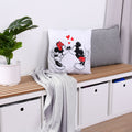 Disney Mickey & Minnie Dekokissen ‘Love’ auf einer Holzbank neben grauem Kissen und Decke