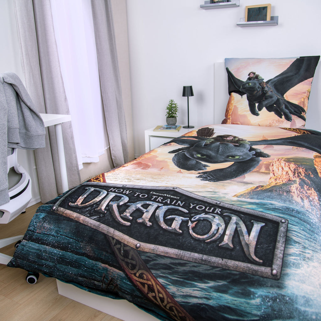 Dragons Bettwäsche ‘Drachenreiter’ auf einem Bett mit Logo „How to Train Your Dragon“