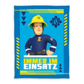 Feuerwehrmann Sam Fleecedecke ‘Einsatz’: Sam in Uniform mit gelbem Helm und Schriftzug Immer im Einsatz auf Blau